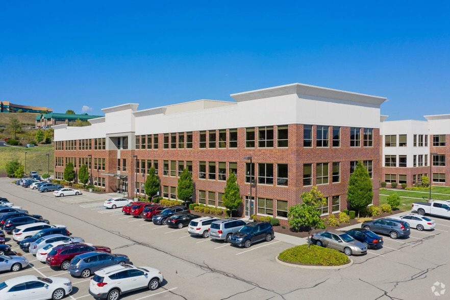 Aerial view of Embassy Park, a three-story brick office building with surface parking