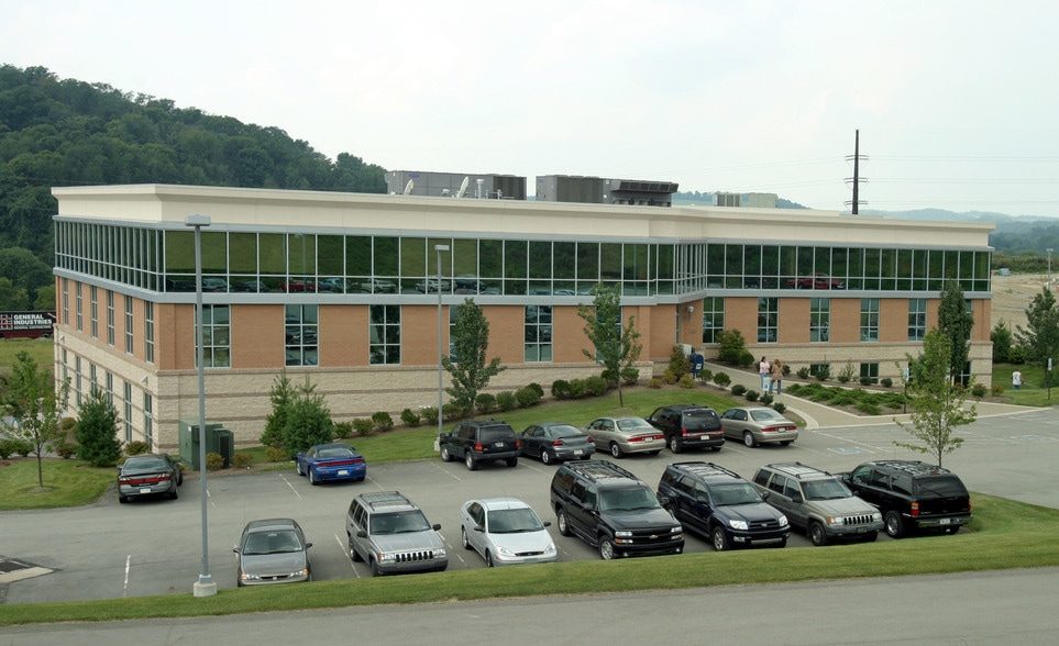 Meadow Pointe I seen across its parking lot, with a continuous band of upper-floor glass