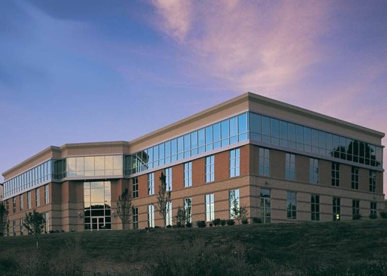 Meadow Pointe I at dusk, showing its brick and glass corner elevation