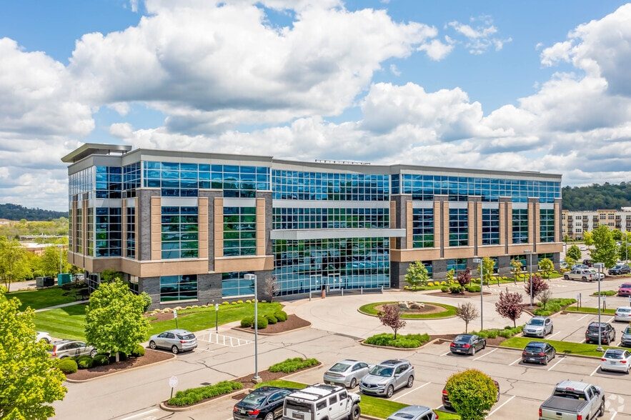 Aerial view of 4000 Town Center Blvd, a four-story blue-glass office building with landscaped parking
